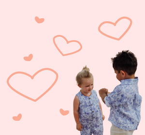 Girl and boy wearing organic linen overalls and shirt from Amber Days. An indigenous-owned Australia labels that features artwork from indigenous artists on their fabrics. These pieces are from the KUU collection. 
